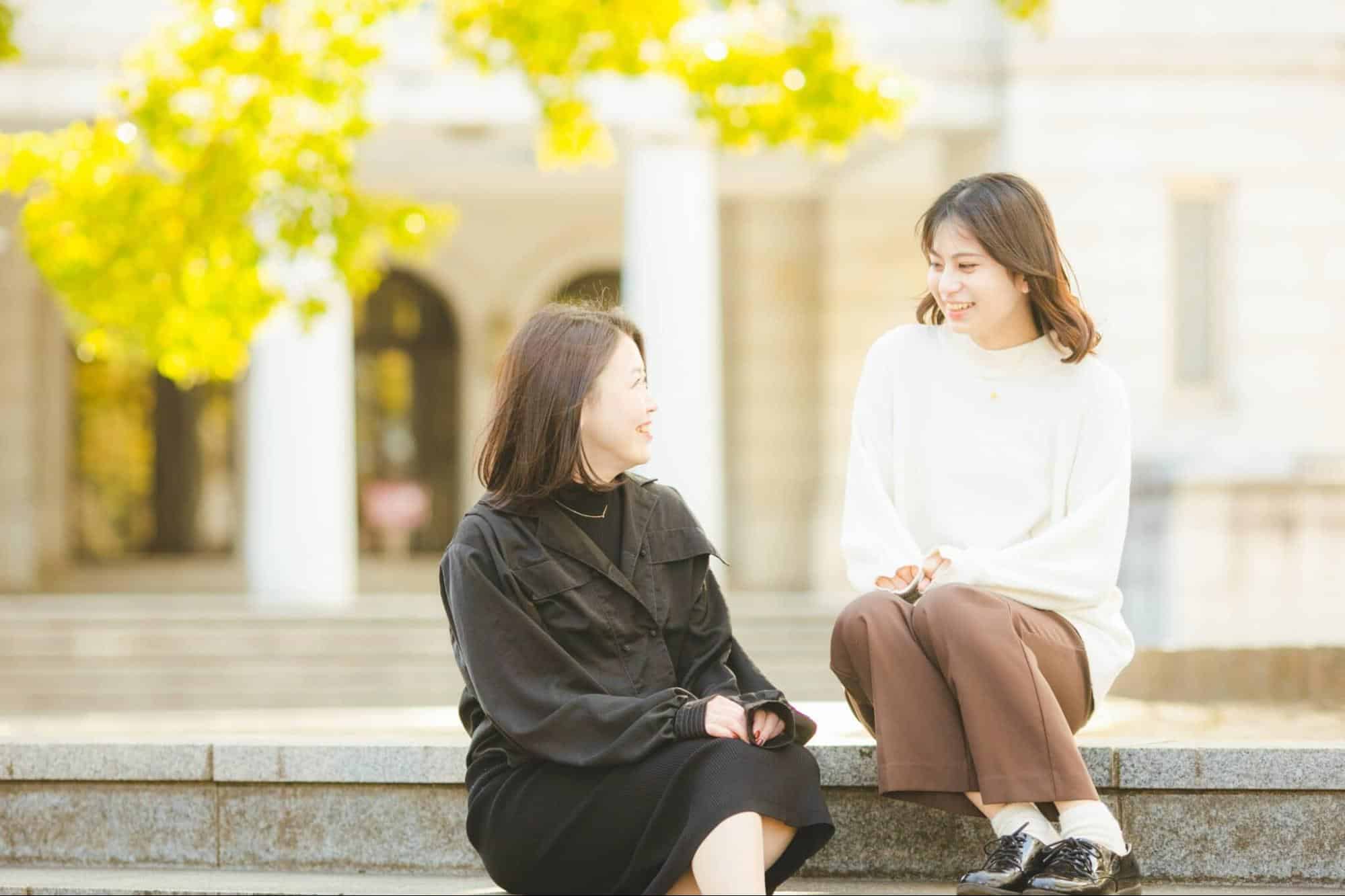 大学キャンパス内で談笑する2人の女性
