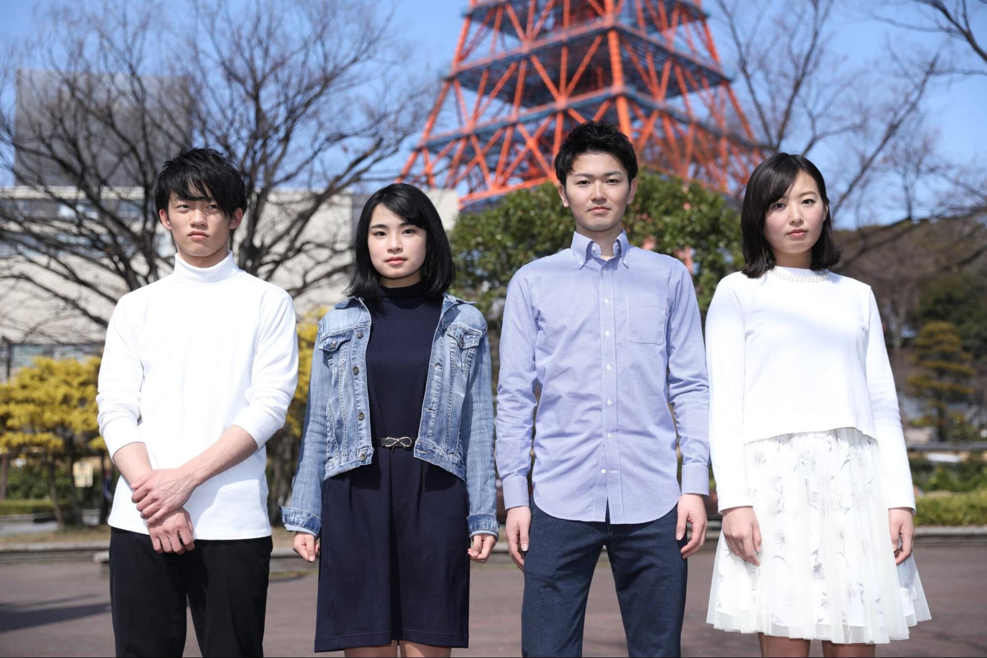 東京タワーの足元に並ぶ男女4名