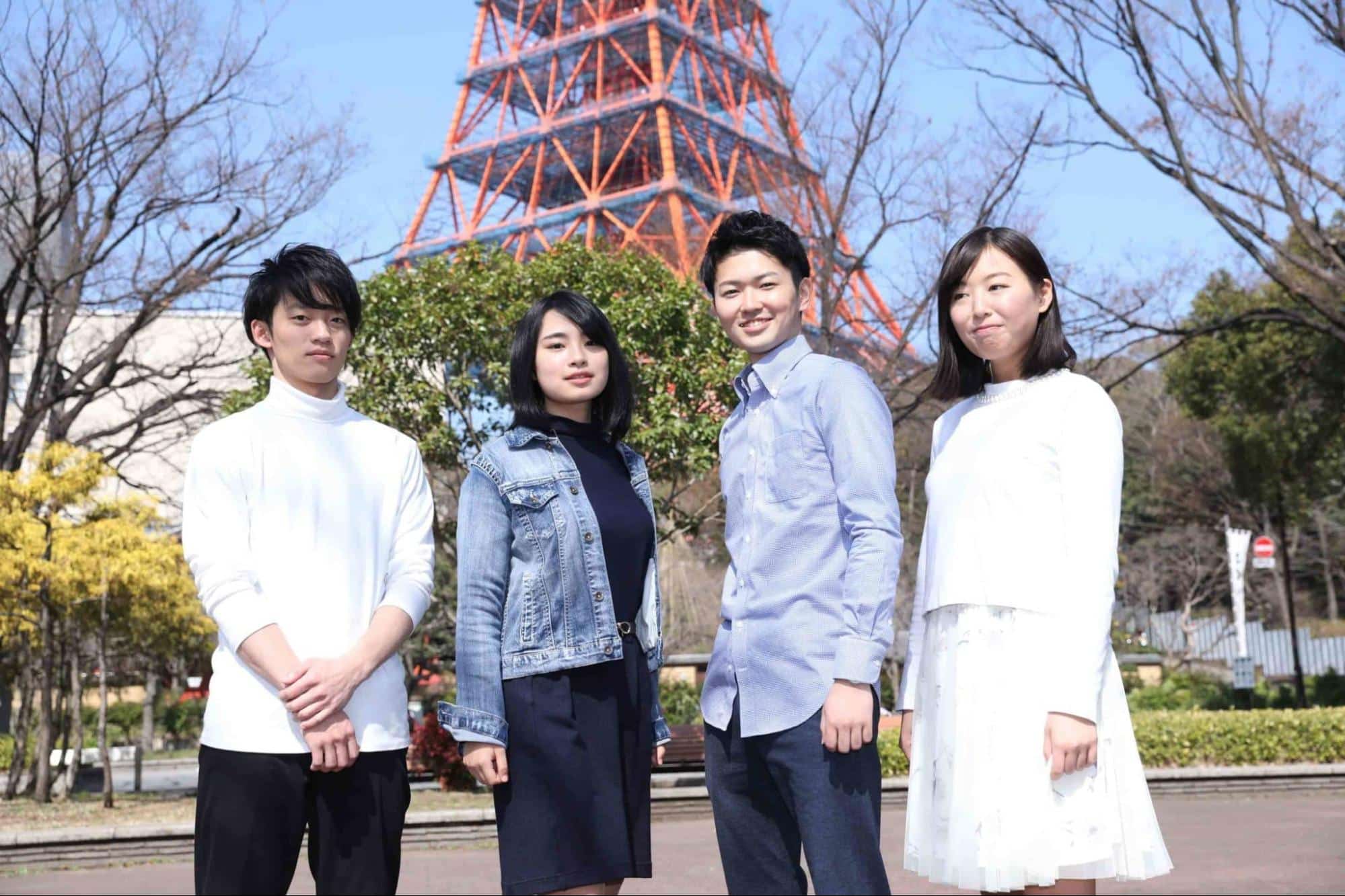 東京タワーの足元に立つ男女4人